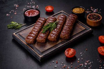 Grilled kebab with spices and herbs on a dark concrete background