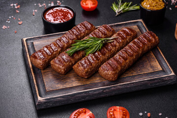 Grilled kebab with spices and herbs on a dark concrete background