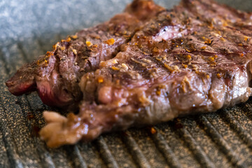 Juicy beef meat steak cooking on griddle pan at professional kitchen. Prime steak frying at grill. Delicious, modern cuisine.