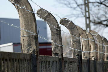 Betonowe ogrodzenie z drutu kolczastego w około obozu imigrantów. - obrazy, fototapety, plakaty