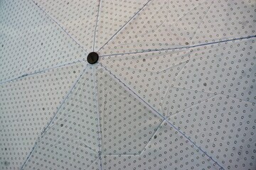 Weißer aufgespannter Regenschirm mit Muster