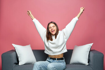 Overjoyed young girl football fan feel euphoric triumph win, raised hands up, watching soccer...