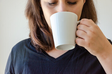 latin woman drinking from a white plain mug