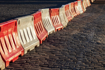 Red and white plastic barriers are set up on the pavement, blocking traffic on the road. Closed...