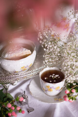 white still life with cheesecake and gypsophila and cup of tea, light and airy
