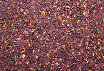 The background of dried leaves of karkade tea is red lilac. Drinks vegetables berries useful agricultural products.