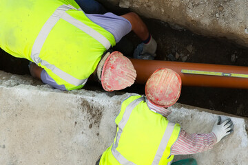 construction workers for repair water  and  sewer pipes in construction site - 494298501