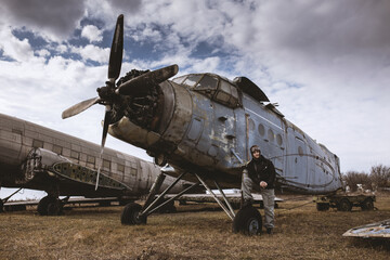 Portrait of young man airplane pilot. Airplane on the background.Old fashion style.