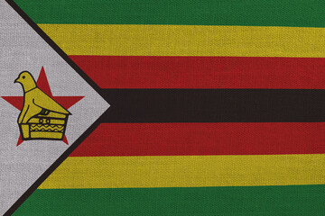 Patriotic textile background in colors of national flag. Zimbabwe