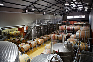 The winemaking process. Wine barrels and fermentation vessels in a factory.