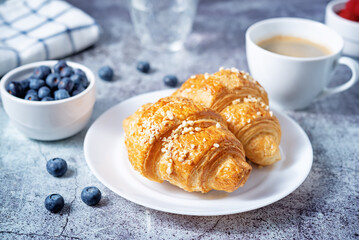 Fresh croissants with berries and cup of coffee