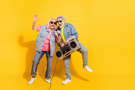 Photo of charming sweet girlfriend boyfriend dressed denim outfit listening boom box singing isolated yellow color background