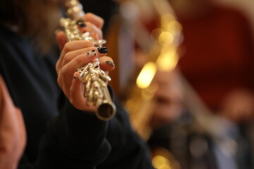 Female hand with nails of a woman playing a musical instrument flute close-up details art photo selective focus © Nina