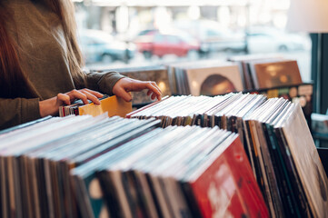 Woman hands choosing vinyl record in music record shop