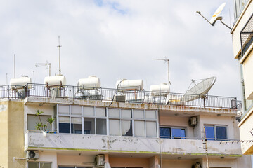 A lot of solar water heating systems with large water tanks and boilers on roof of house