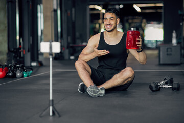 Fototapeta na wymiar Smiling Arab Man Recommending Fitness Supplements For Bodybuilding In His Fitness Blog