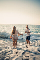 Happy couple by the sea. Honeymoon lovers. Man and woman on the island. Beautiful couple having fun on the seashore. Happy couple on vacation. Man and woman by the sea.