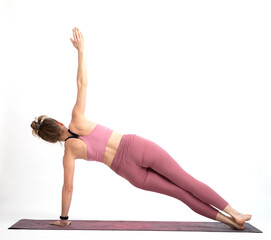 woman doing yoga on a white background Santolanasana balancing pose or side plank