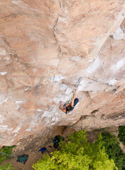 Fit, strong girl reaching for holds while sport climbing