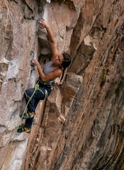 Beautiful, fit brown woman sport climbing