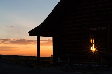 Silhouette of cabin against a colorful sunset