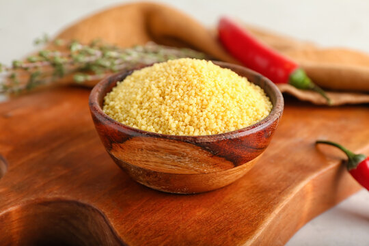 Bowl of raw couscous on table, closeup