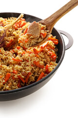 Frying pan with tasty Asian pilaf on white background