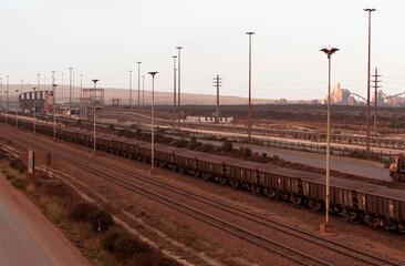 Fototapeta na wymiar Saldanha Bay, West Coast, South Africa. 2022. Railway trucks carrying iron ore from Sishen to Saldanha Bay terminal on the West Coast of South Africa.
