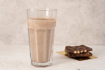 Delicious homemade cocoa drink with milk, cocoa powder and pieces of chocolate bar. Close-up.