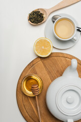 Obraz na płótnie Canvas Top view of teapot near honey and lemon on white background.