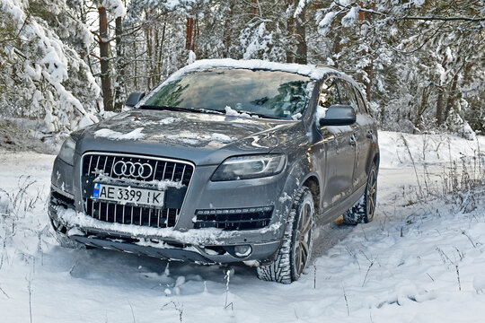 Ukraine, Novomoskovsk 12/26/2021. Large SUV Audi Q7 in a snowy forest among snowdrifts.