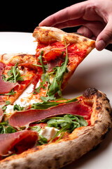 delicious italian pizza with tomatoes, ham, salami, cheese on a white background