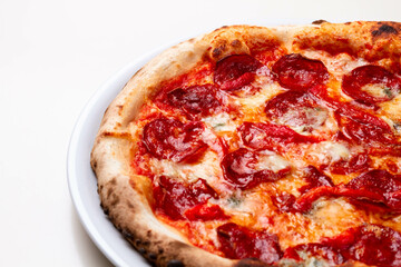 delicious italian pizza with tomatoes, ham, salami, cheese on a white background