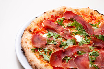 delicious italian pizza with tomatoes, ham, salami, cheese on a white background