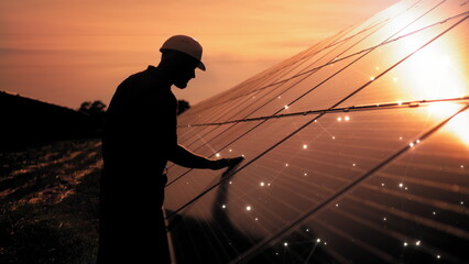 Unidentified solar power engineer touches solar panels with his hand at sunset. Receiving Photons...