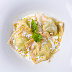 Ravioli in cream sauce with parmesan on a white background