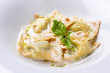 Ravioli in cream sauce with parmesan on a white background