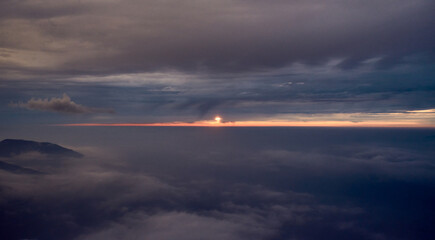 SOL AL ATARDECER ENTRE LAS NUBES Y EL HORIZONTE