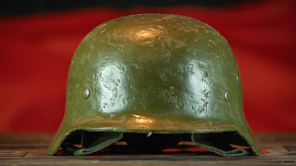 Close-up view of green metal military helmet on red background. Russian camo helmet. War concepts.