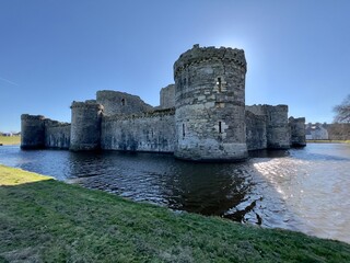 Moat around Beaumaris Castle with blue skies