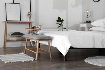 Interior of modern bedroom with bench and comfy bed