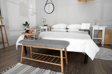 Interior of modern bedroom with bench and comfy bed