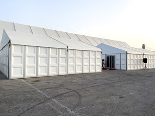 a large white wedding tent set up outside for a catered event