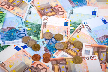 Background of banknotes and euro coins of different denominations close-up - Powered by Adobe