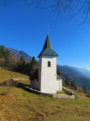Fototapeta na wymiar Church at St. Lovrenc in mountains, Gorenjska, Slovenia surrounded by a low stone wall