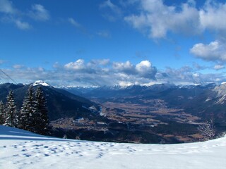 Obraz premium Scenic view of Gailtal in Carinthia or Karnten in Austria covered in farmland and surrounded by high mountains of Gailtal Alps in winter from Tromeja or Mt. Ofen