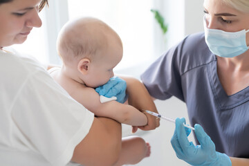 Pediatrician doctor with syringe, tense mother and baby