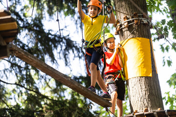 Happy child climbing in the trees. Rope park. Climber child. Early childhood development. Roping...