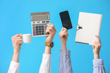 Business people with cup of coffee, calculator, mobile phone and folder on blue background
