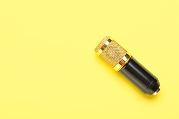Modern microphone on yellow background